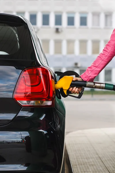 Woman filling up car at petrol station black car — Stock Photo, Image