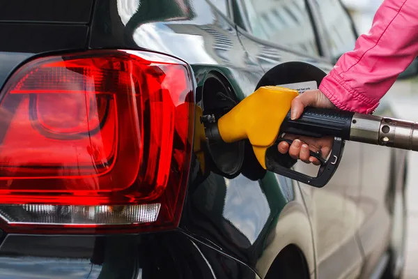 Mujer llenando el coche en la gasolinera coche negro Fotos De Stock Sin Royalties Gratis