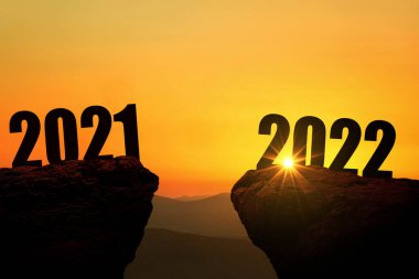2022 yılbaşı gecesi gün batımında dağda, konsept. 2021 ve 2022 'de gün doğumunda uçurumda, yaratıcı bir fikir. Tasarım için boş alan