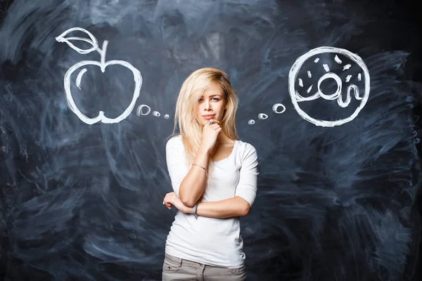 Beautiful Young Blonde Woman Makes Choice Apple Donut Background Chalk — Stock Photo, Image