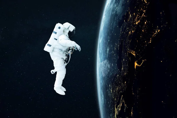 太空人在蓝色的地球附近的外层空间飞行 夜间有巨型飞机的灯光 宇航员开始在轨道上执行任务 空间与人类壁纸 — 图库照片