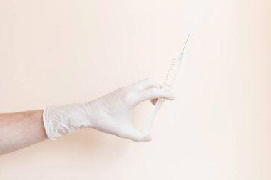Hafif arka planda şırınga olan lastik bir eldiven verin. Doktor enjeksiyon yapıyor.