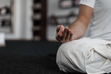 Spor salonunda meditasyon yapan genç bir adamın yakın çekimi. Yoga ve sağlıklı yaşam tarzı konsepti. Dinlenme zamanı..