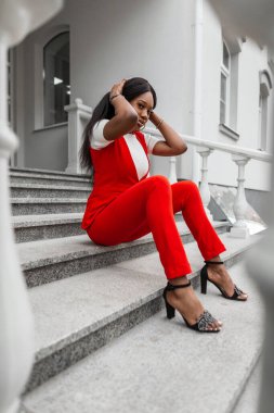 Moda ayakkabıları içinde seksi dudakları olan modern çekici siyah kadın yaz günü şehrin klasik taş merdivenlerinde dinleniyor. Sokakta poz veren Afrikalı güzel kız..