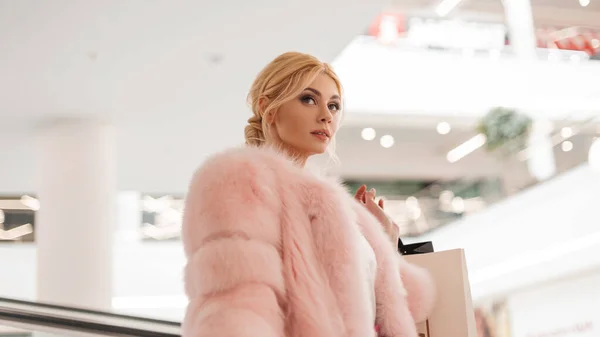 초록빛 코트를 쇼핑몰에 머리를 호화로운젊은 비지니스걸 모델은 가게를 돌아다니고 있습니다 — 스톡 사진