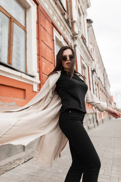 Mujer joven de moda en ropa casual juvenil negra se encuentra cerca del  edificio vintage en la ciudad. de cerca. nueva colección de primavera con ropa  elegante para mujer.