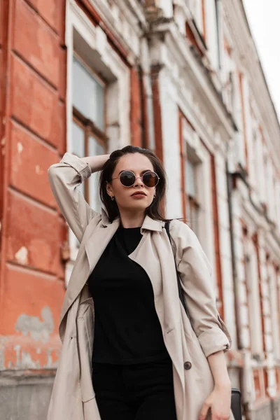 Mujer joven de moda en ropa casual juvenil negra se encuentra cerca del  edificio vintage en la ciudad. de cerca. nueva colección de primavera con ropa  elegante para mujer.