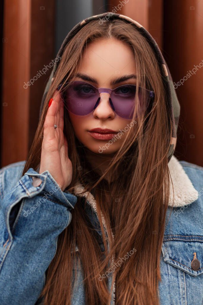 Mujer hipster con estilo joven fresco en ropa juvenil casual de moda en  gafas moradas de moda posa en la ciudad. modelo de moda de chica glamorosa  sexy estadounidense se sienta en