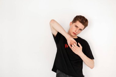 Moda hippisi siyah tişörtlü adam stüdyoda.