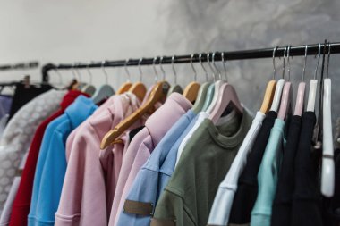 Giysi rafındaki moda kıyafetleri - parlak renkli dolap. Mağaza dolabında ya da bahar temizliği konseptinde elbise askısı takan modaya uygun kadın renk seçimi