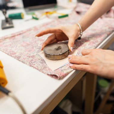 Kumaşlı terzi stüdyoda çalışıyor. Moda tasarımcısı yakın plan. Giysi imalatı