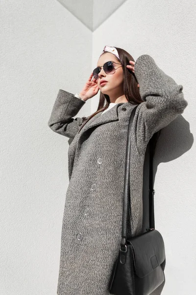 아름다운 코트를 가죽검은 가방을 아름다운 코트를 고전적 선글라스를 품위있는 유행하는 — 스톡 사진