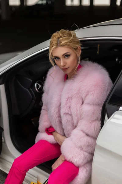 코트를 자동차에 유행하는 스타일의 유행하는 바지를 모델의 아름다운 매력적 소녀는 — 스톡 사진