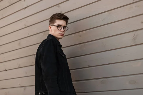 Yakışıklı Şehirli Genç Adam Şehirde Ahşap Duvarın Yanında Şık Gözlükleri — Stok fotoğraf