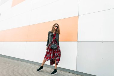 Moda gençliği, siyah, deri ceketli ve modern alışveriş merkezinin yakınında şık pozlar veren koyu renk güneş gözlüklü şehirli hippi kızlar. Havalı, havalı, çekici kadın dışarıda yürüyor..