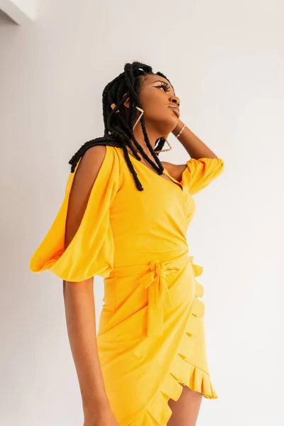 노란색 드레스를 스튜디오에서 배경에 포즈를 취하고 아프리카 미국인 실내에서 색옷을 — 스톡 사진
