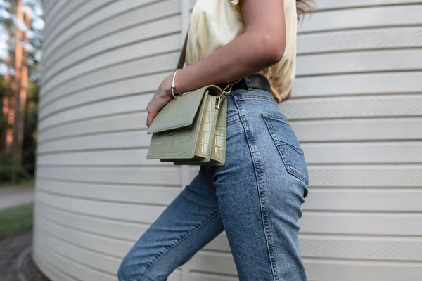 ファッションブルーのクラシックなジーンズを着たクールなヒップスター女性革のハンドバッグが通りを歩いて クローズアップ — ストック写真