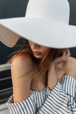 Plajda beyaz şapkalı güzel bir model kız. Hafta sonu moda kıyafetleri içinde bir kadın..