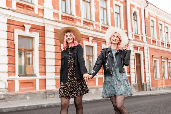 연미복을 밀짚모자를 즐거운 여자들 이손을 밖에서 미소를 유행하는 친구들 시에서 — 스톡 사진