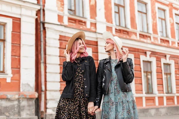 청소년 모자를 멋있는 쌍둥이가 서로를쳐다본다 아름다운 복장의 자매들은 도시의 근처를 — 스톡 사진