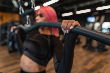Spor salonunda egzersiz yapan genç kız, spor aletleri makinesini kapat.