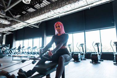 Spor mankeni genç bir kadın spor salonunda spor yapıyor ve egzersiz yapıyor.