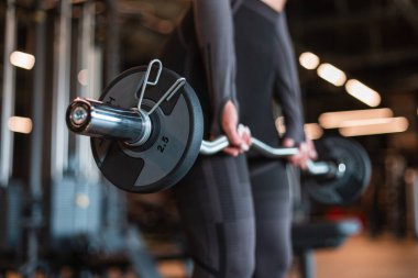 Sağlıklı, güçlü spor giyim eğitmeni kadın spor giyiniyor ve bir barda antrenman yapıyor ve spor salonunda egzersiz yapıyor.