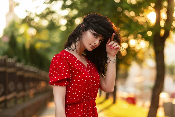 ファッションエレガントなレトロな赤いドレスの美しい巻き女性は日没時に屋外に立つ — ストック写真