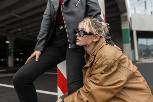 Mujer con estilo de moda en elegante blazer largo en pantalones de  mezclilla vintage en camiseta cerca de edificio moderno en la calle. chica  de moda en ropa vintage en la ciudad.