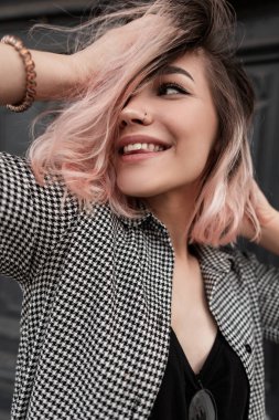 Moda kıyafetleri içinde beyaz gülüşlü mutlu genç bir kadının taze duygusal portresi.