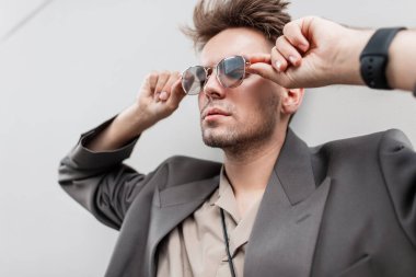 Havalı bir iş adamı portresi. Saç stili ve sakallı. Giysileri, ceketi ve gömleği var.