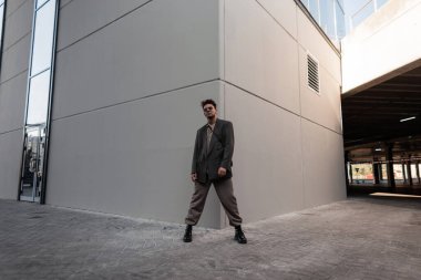 Şık giyinen, şık giyimli, gömlekli, ceketli, pantolonlu ve botlu bir model. Erkek şehir tarzı ve moda