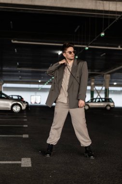 Park yerinde şık giyinmiş şık genç bir iş adamı var. Erkeklerin şehir tarzı ve modası