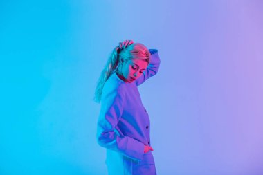 Çok renkli neon ve pembe ışıkta şık giyinen şık bir kadının kadın portresi.