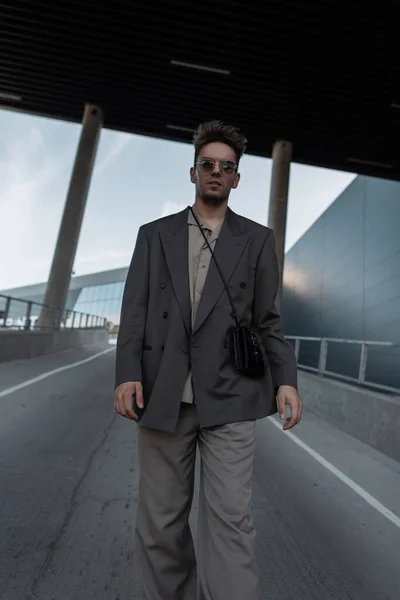 街の背景に財布の散歩でファッショナブルな衣装で頑丈ハンサムなビジネスマン — ストック写真