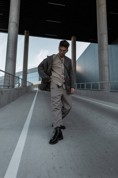 Красавчик хипстер в костюме моды гуляет по городу. Городской стиль