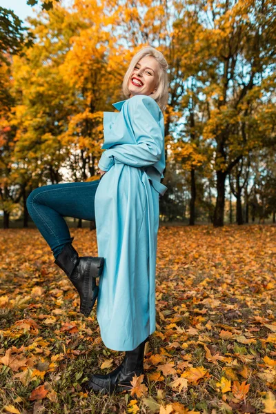 청바지를 유행하는 파란색 외투를 구두를 아름다운 노랗고 나무와 자연스럽게 휴식을 — 스톡 사진