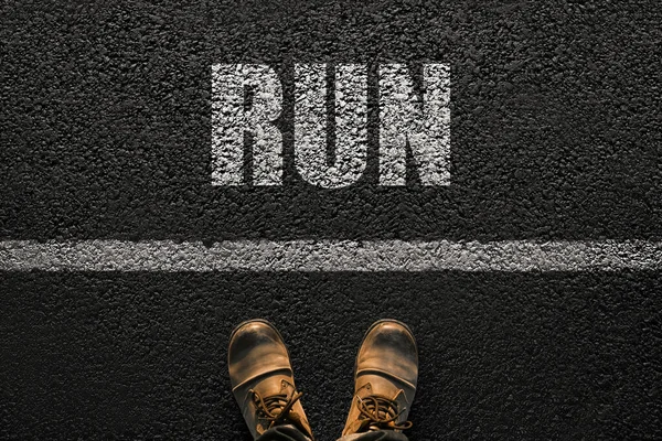 穿着靴子的男足站在白线附近的柏油路上 说着跑步 健康的生活选择 概念健康和成功 — 图库照片