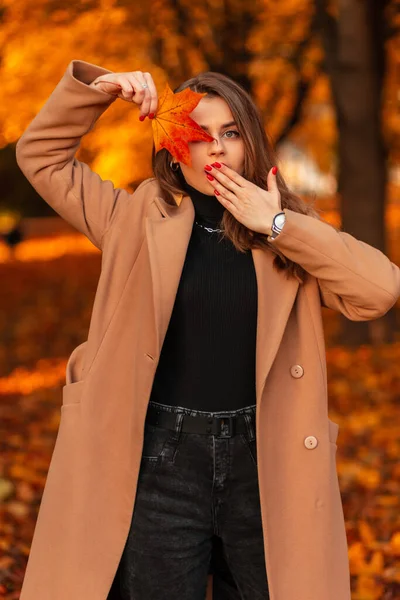 가랑잎이 베이지 아름다운 여인이 오렌지 잎사귀가 공원을 여행하는 새로운 컬렉션 — 스톡 사진