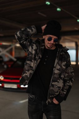 Havalı, yuvarlak güneş gözlüklü, askeri ceketli, kazaklı ve kırmızı arabalı havalı hippi mankeni.