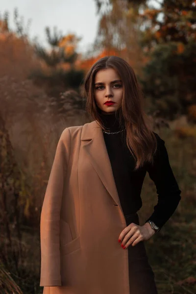 一个美丽的女孩的自然肖像 穿着时髦的米黄色外套和一件黑色毛衣 在草地上的自然 优雅的女性风格和美 — 图库照片