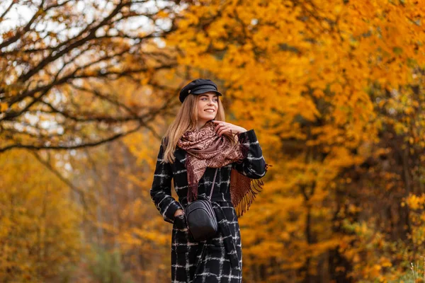 ファッションコート スカーフ 帽子でかわいい笑顔で幸せな女性は黄金の紅葉と秋の公園を歩く — ストック写真