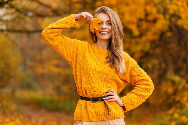 스웨터에 웃음을 머금은 아름다운 잎으로 공원에서 잎으로 얼굴을 뒤덮고 스타일 — 스톡 사진