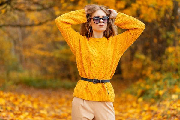 스러운 노란색 스웨터를 아름다운 여성의 은가을에 형형색색의 잎으로 자연속을걸어 다닌다 — 스톡 사진