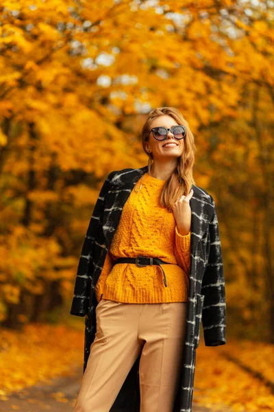 秋のファッションで笑顔の若い幸せな女性は黄色のカエデ公園の背景でお楽しみください 女性の楽しい感情 — ストック写真