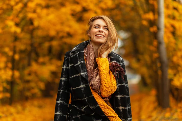 노란색 스웨터에 스카프를 코트를 나무와 노란색 산책하고 아름다운 소녀는 행복해 — 스톡 사진