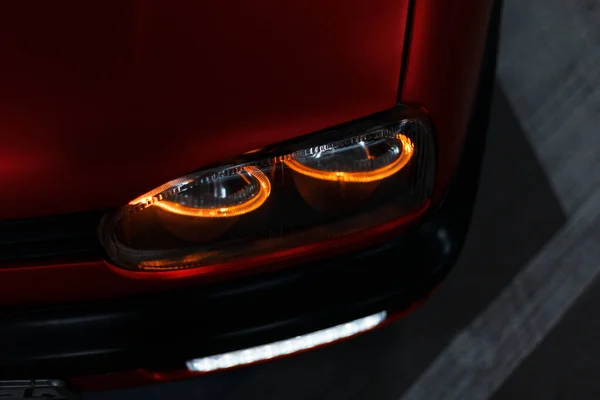 夜间街上一辆红色调优汽车上的现代前照灯 — 图库照片