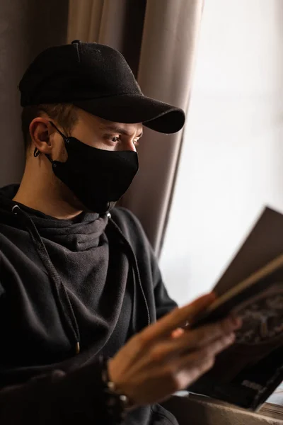 Jonge Man Met Medisch Beschermend Masker Zwarte Pet Hoodie Reading — Stockfoto