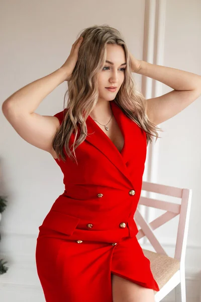 Gelukkig Vrouw Elegante Rode Modieuze Jurk Zit Stoel Witte Kamer — Stockfoto