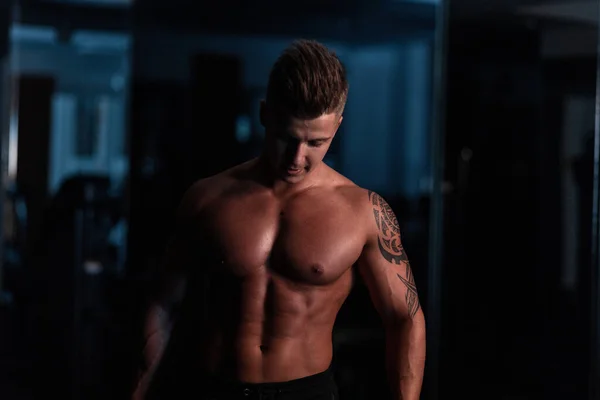 Μυώδης Bodybuilder Τύπος Στέκεται Στο Γυμναστήριο Στο Σκοτάδι — Φωτογραφία Αρχείου